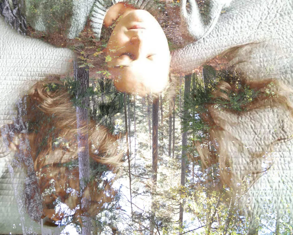 Photograph from the series Behind the Looking Glass by Anna Wiksten: a woman with forest in her hair.