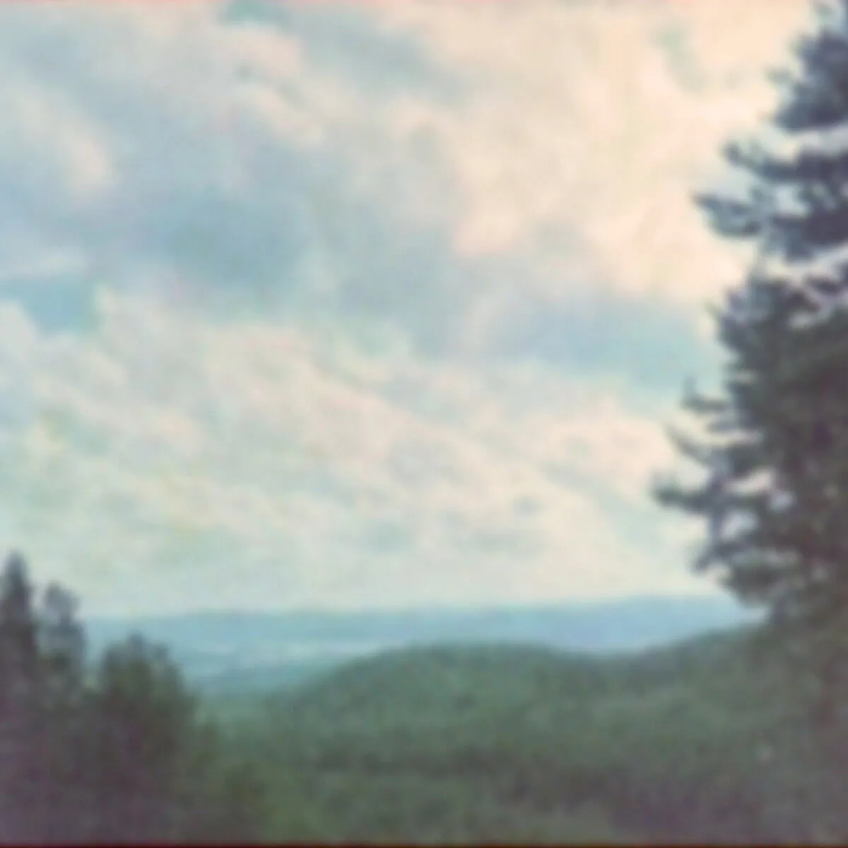 Fotografi ur serien Memory Starts Here av Anna Wiksten: utsikt med berg och himmel, inskannat negativ från 2000-talet.