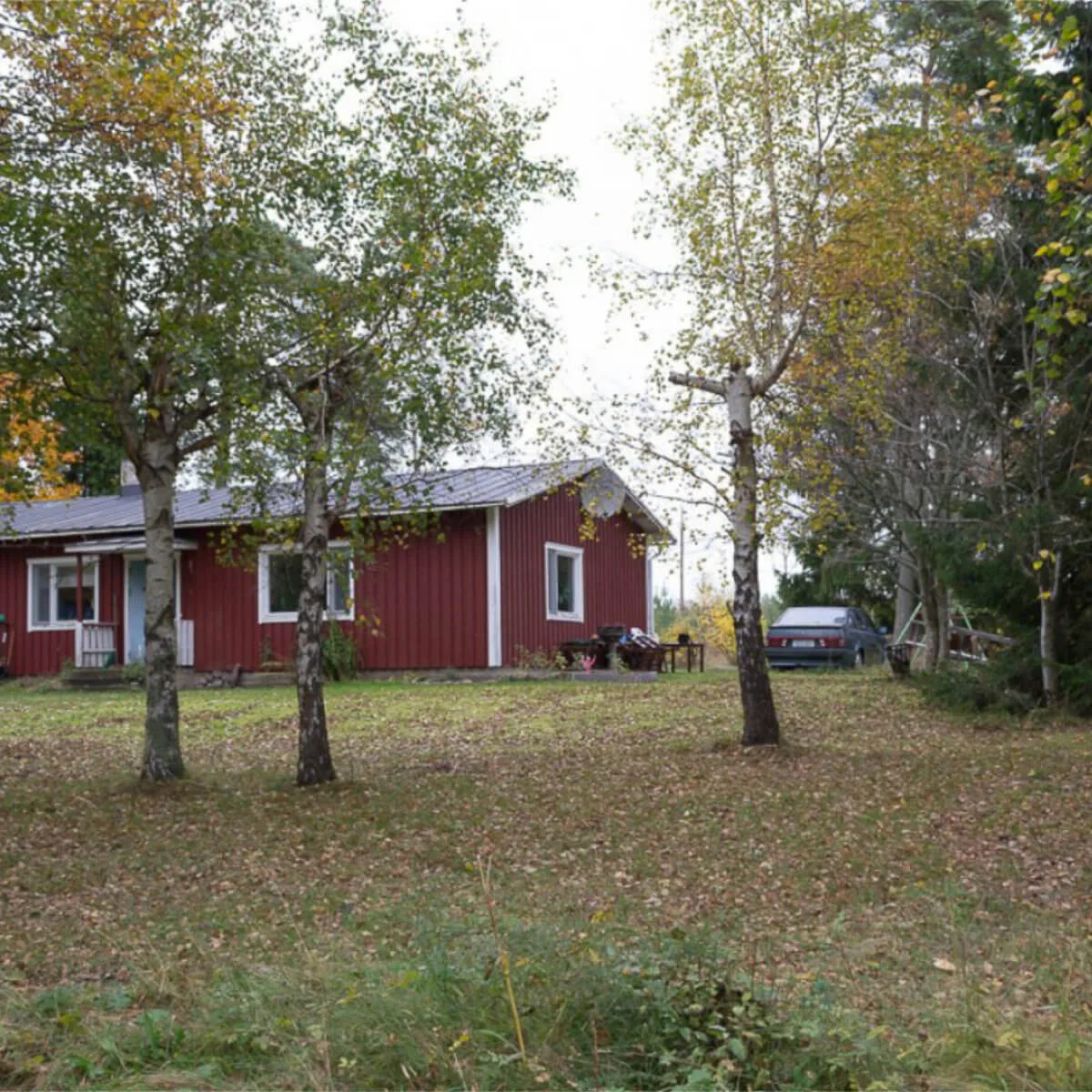 Fotografi av Anna Wiksten: ett rött hus med vita knutar i höstlig miljö.