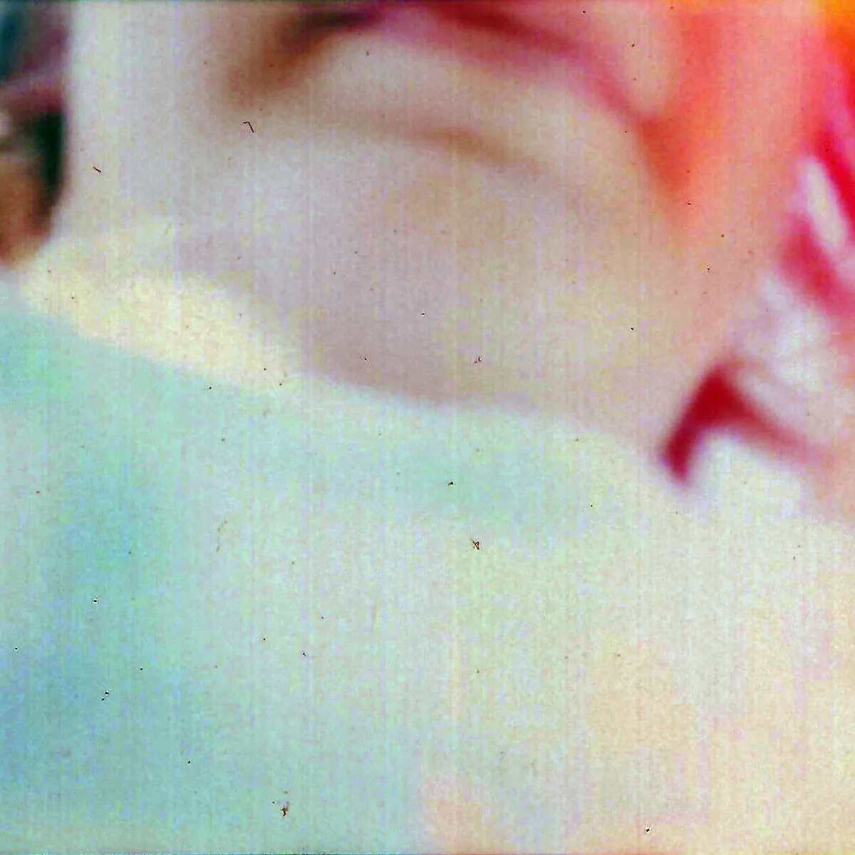 Fotografi ur serien Memory Starts Here av Anna Wiksten: suddigt halvt ansikte, inskannat negativ från 1990-talet.