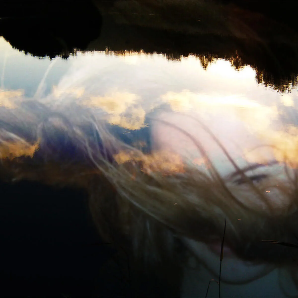 Fotografi ur serien Behind the Looking Glass av Anna Wiksten: kvinna som sjunker ner i vatten.