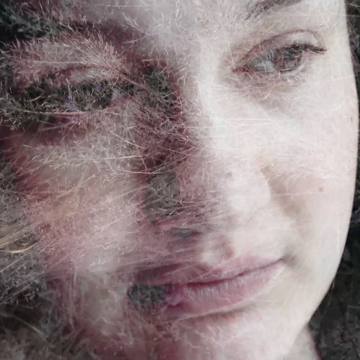 Fotografi ur serien Behind the Looking Glass av Anna Wiksten: kvinna med torkade gräsvippor.